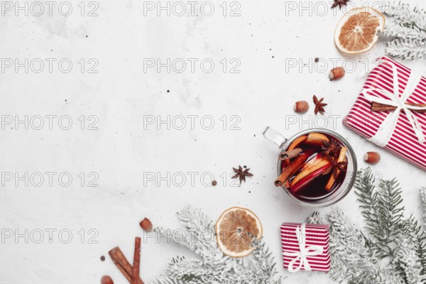 Christmas flat lay top view on white gray concrete background table with glass cup or mug of Mulled