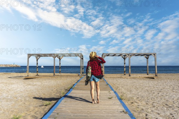 A young tourist on the wooden walkway of San Jose beach in the town of Nijar, Almería. Andalusian
