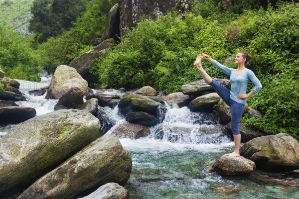 Yoga outdoors, woman doing Ashtanga Vinyasa Yoga balance asana Utthita Hasta Padangushthasana,