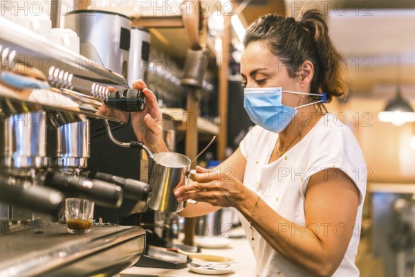 A waitress with a face mask in a bar. New normality, security measures after the coronavirus