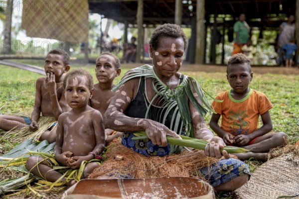 Local woman preparing banana leaves with roasted marrow of the Sago palm, village Pangoa, island