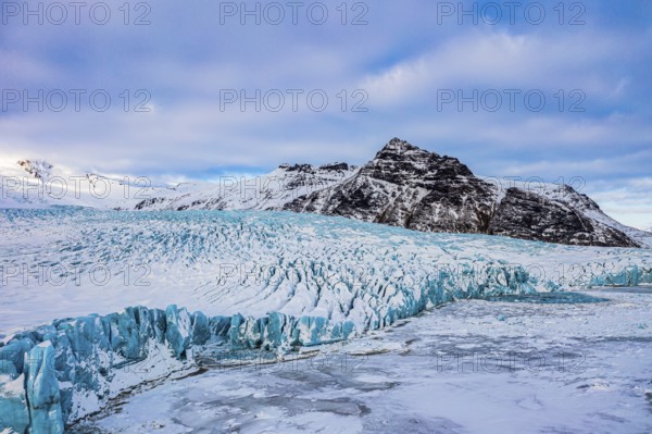 Snow-covered icebergs in the Fjallsarlon glacier lagoon, with the Öraefajökull glacier behind,