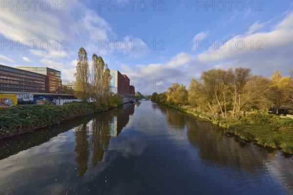 General architecture, trees, canal to the flood basin, blue sky with nimbostratus and cumulus
