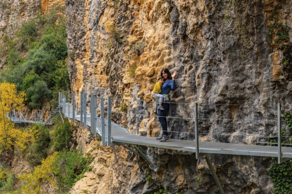 Very happy woman and son walking along the metal walkways of the Vero River path in Alquezar.