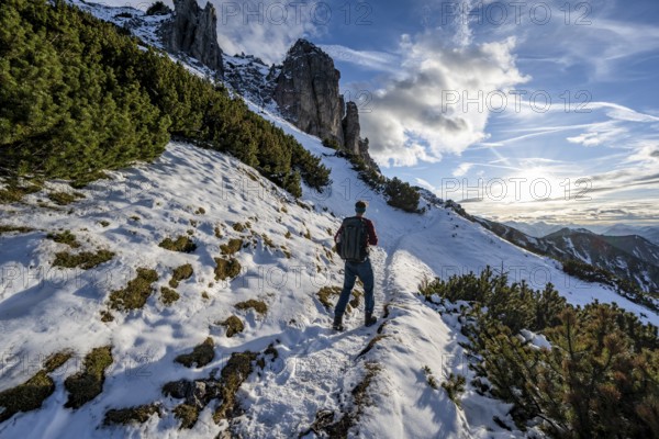 Hikers on a hiking trail with snow, ascent to Kramerspitz, in autumn, Ammergau Alps, Bavarian