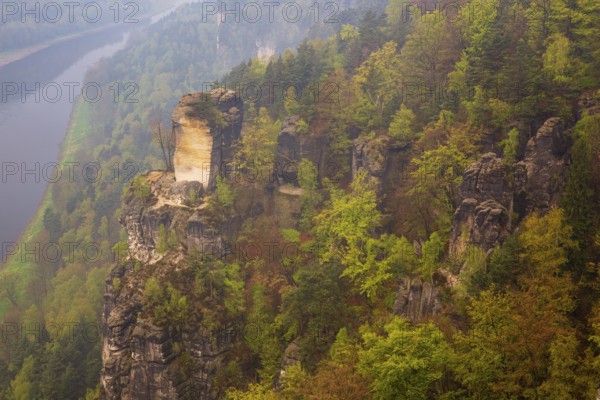 The bright lit Wartturm above the Elbe river seen from the Bastei rocks near the village of Rathen