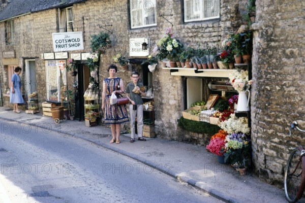 Stow on the Wold, Gloucestershire, England 1963 Woman and boy posing in front of a fruit shop in