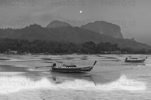 Before sunrise, longtail boats lie at low tide in the harbour at Sivalai Beach, Koh Mook Island,