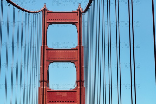 Orange pylon and steel cables of the suspension bridge, detail, Golden Gate Bridge, blue sky, San