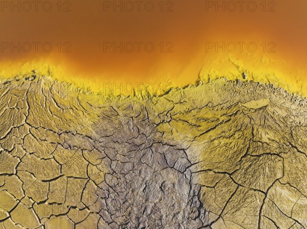 Cracked earth at the bank of the Rio Tinto (Red river) with its deep reddish hue due to oxidised