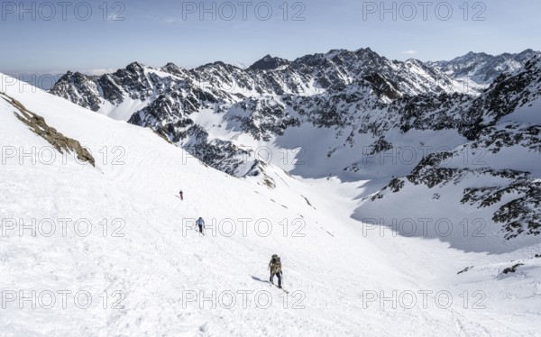 Ski tourers climbing Sulzkogel, Schartenkopf and Schöllekogel in the background, Kühtai, Stubai