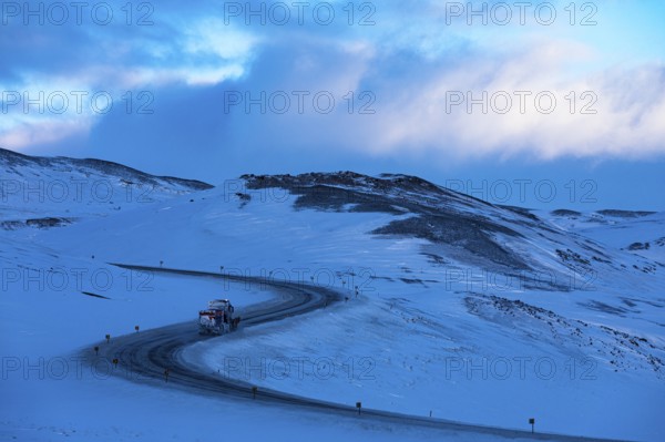 Snow removal vehicle on ice on Ring Road No. 1, snow-covered geothermal area, North Iceland