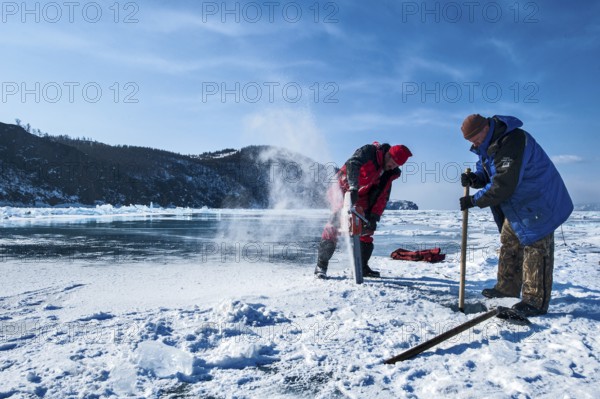 Digging a hole in the ice for scuba diving, Lake Baikal, Olkhon Island, Pribaikalsky National Park,