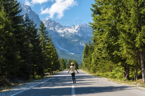 A young tourist woman walking on the road in the Valbona valley, Theth national park, Albanian