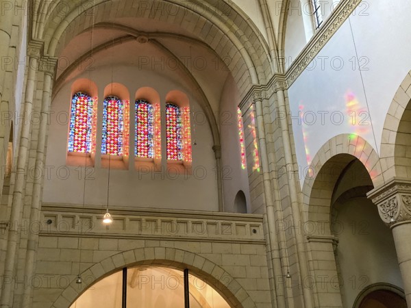 Sun shines through four stained glass windows above main portal of Benedictine Abbey Gerleve casts