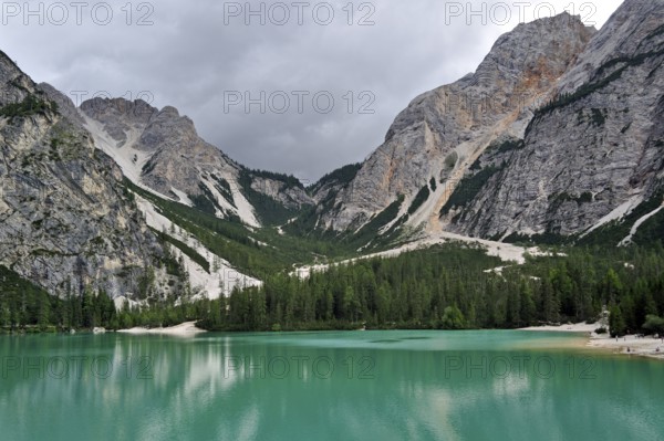 Turquoise water of the Lake Prags Lake, surrounded by pine forest and mountains in the Lake Prags