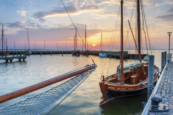 Sailboats and Zeesenboats in the harbour of Dierhagen on the Saaler Bodden at sunrise,