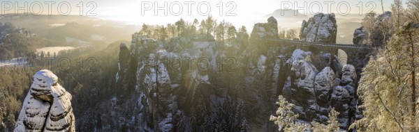 Panorama of Neurathen Castle and the Bastei Bridge on a winter morning, in the background the