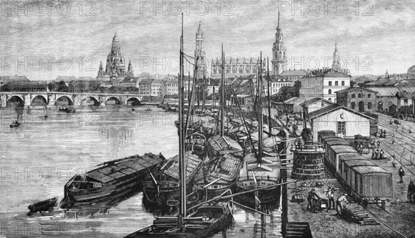 City view of the Saxon capital Dresden on the Elbe, harbour with barges, railway with freight