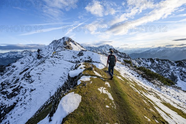 Mountaineer on hiking trail, mountain landscape with snow in autumn, summit and ridge of the