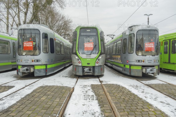 View of a TW 3000 and TW 2000 train of the Üstra with a strike poster stuck to the windscreen,