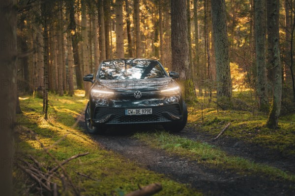 Car driving along a wooded path in a warm autumn atmosphere, car sharing vehicle Deer Mobility,