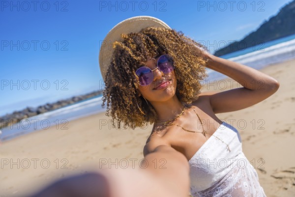 Personal perspective of a cute beauty latin woman in summer clothes, sunglasses and sun hat taking