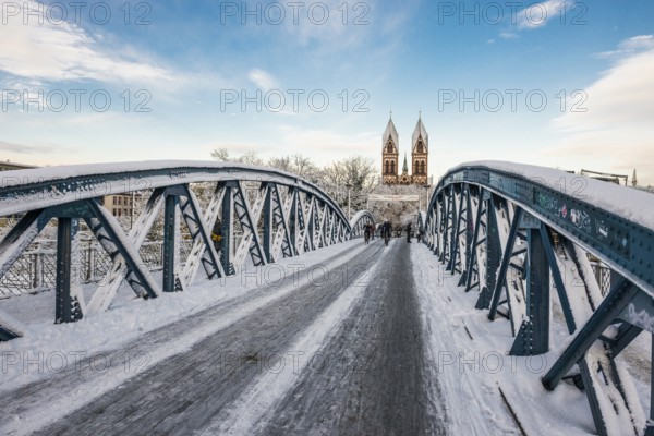 Bridge with snow and ice and cyclists, Blue Bridge and Stühlinger Church, Freiburg im Breisgau,
