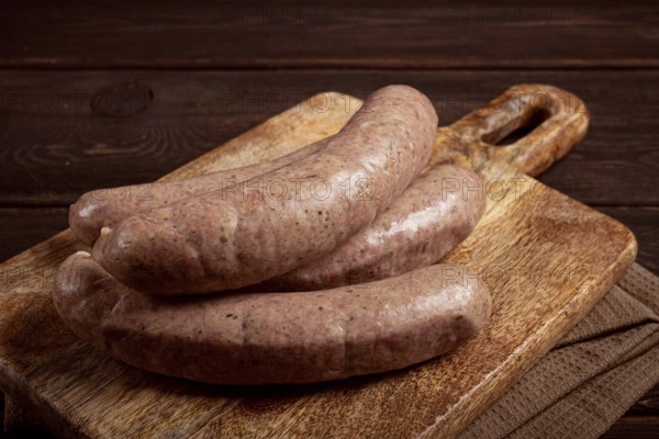 Raw sausages in English with bacon, for grilling, on a cutting board, top view, no people