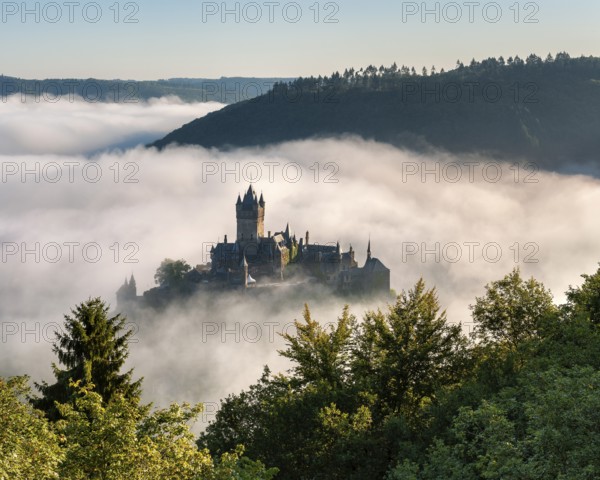 View of the Reichsburg Cochem in autumn, morning mist in the Moselle valley, Cochem,