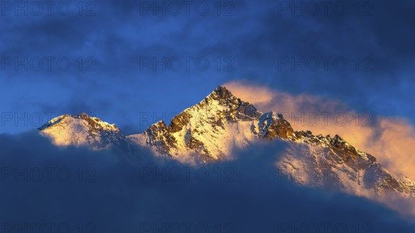 Snow-covered summit of the Weisshorn mountain, illuminated by the evening sun, view from Grimentz,