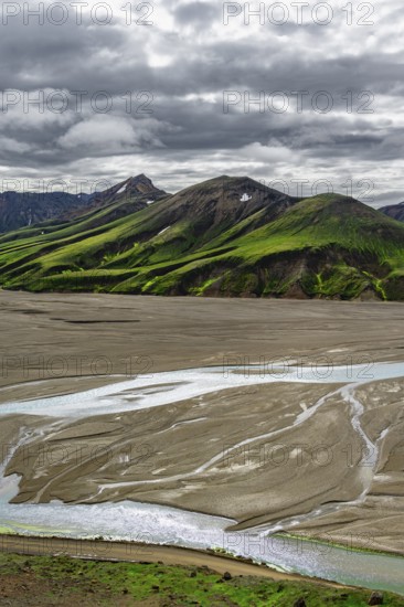 River in large riverbed, Moss-covered mountains, Rhyolite mountains, Volcanic landscape,