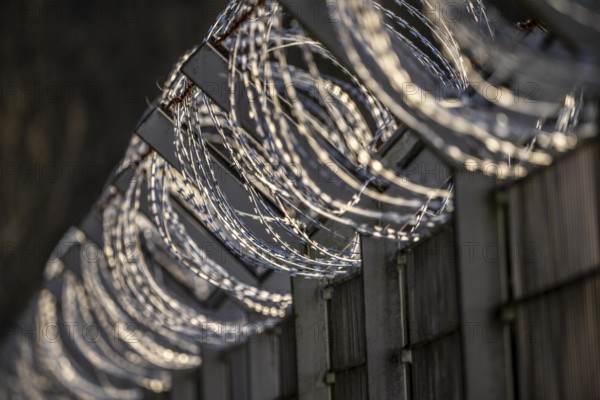 Symbolic image security, S-wire rolls, NATO wire, on a fence top, demarcation of a property,