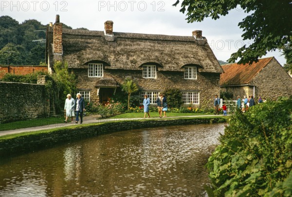 Touristen spazieren am attraktiven reetgedeckten Beck Isle Cottage, Thornton Beck stream, Thornton