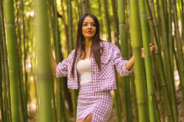 Young caucasian girl with a pink skirt in a bamboo forest. Enjoying the city on summer vacation in