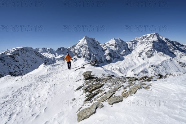 Ski tourers on foot, mountain panorama with snow-covered mountain landscape in winter, view of