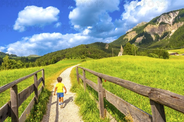 Young tourist walking on a path towards the famous st. Magdalena church in val di funes in the