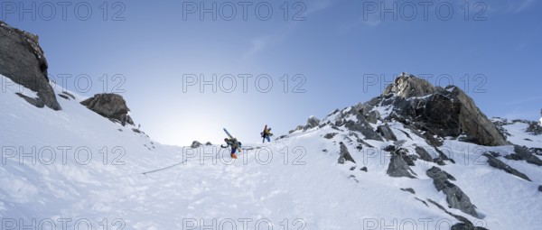 Mountaineer with skis descending through a steep snowfield on the Porta d'Es-cha, in winter, alpine