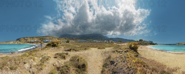 Wide Frangolimiona sandy beach with views of the blue sea, dramatic clouds and a vast coastal