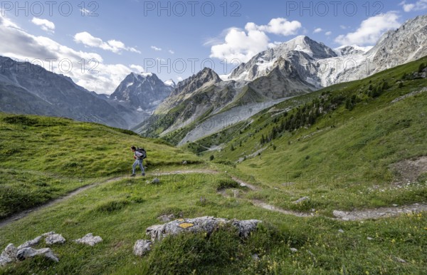 Mountaineer on a hiking trail, mountain landscape near Arolla, in the background mountain peak Mont