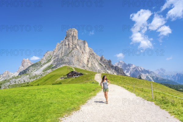 Female tourist enjoying hiking on a sunny summer day at the scenic giau pass in the italian