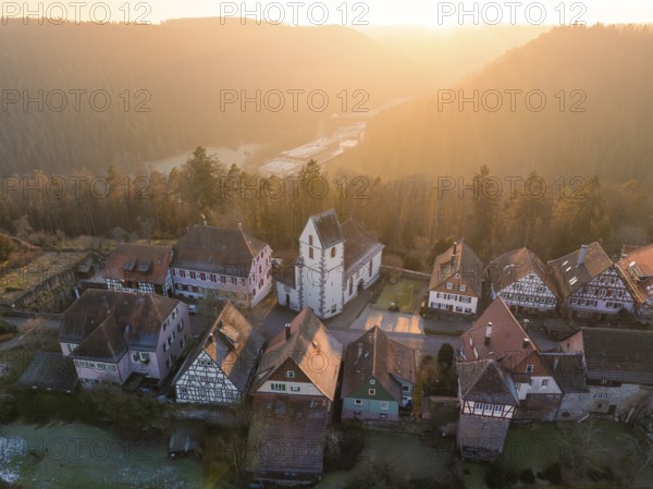 Small village with church and half-timbered houses in a hilly landscape at sunrise, Zavelstein,
