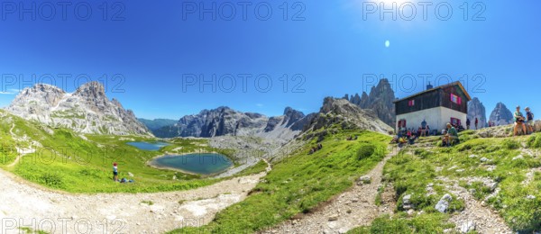 Tourists enjoying breathtaking views while hiking near the tre cime di lavaredo peaks and mountain