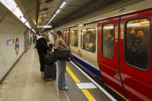 Crowded underground tube train arriving at station platform, Kings Cross Station, London, England,
