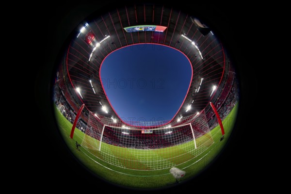 Overview, interior, floodlit match, behind-the-goal perspective, goal net, blue hour, fisheye shot,