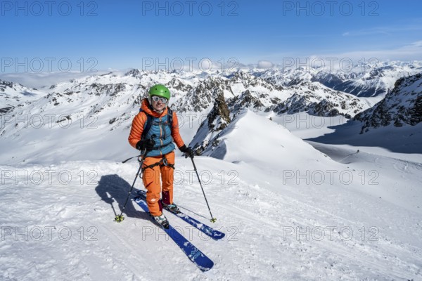 Ski tourer descending Piz Kesch on the Vadret da Porchabella glacier, view of mountain panorama in