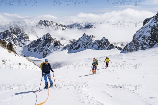 Ski tourer with rope, rope team on the Vadret da Porchabella glacier on the ascent to the summit of