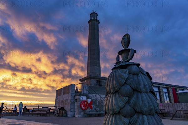 Bronze sculpture Mrs Booth The Shell Lady and the Margate lighthouse at sunset, Kent, England,