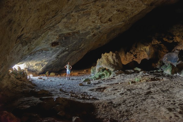 Woman in the darkness of the vast Limniatis Cave, Hike from Aperi to Limniatis Cave, Limniatis