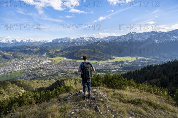 View of Garmisch-Partenkirchen and mountain panorama, mountaineer on hiking trail to Kramerspitz,